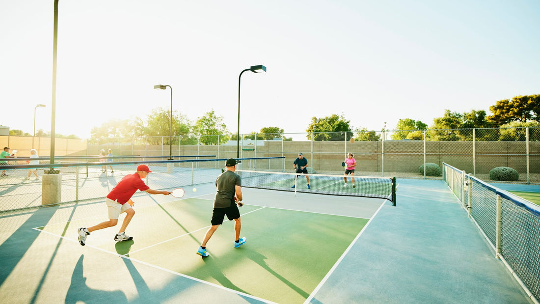 A group of people at a pickleball court showcasing a pickleball net and balls