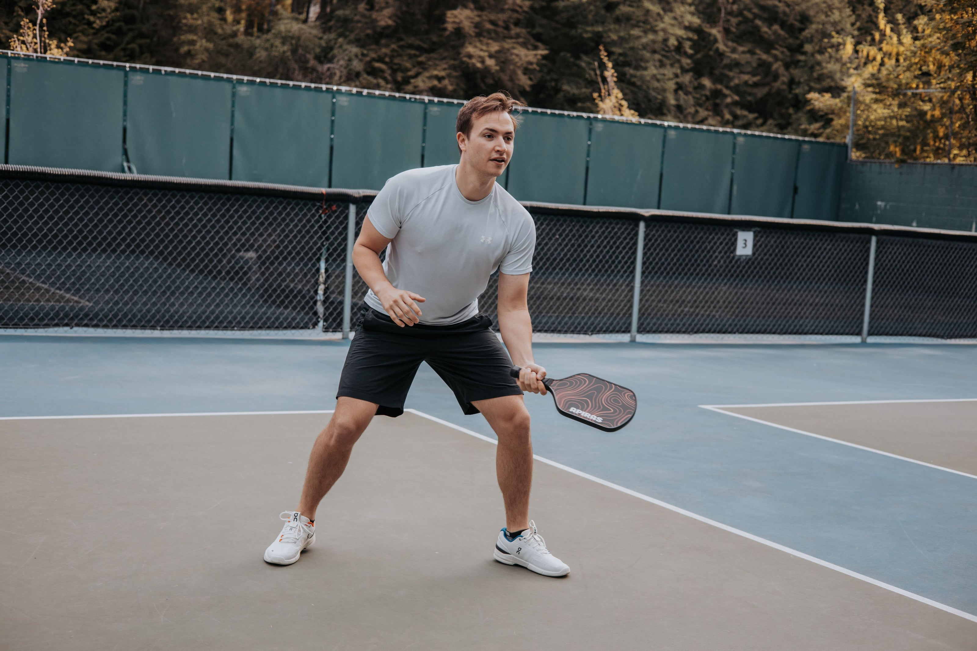 A man getting ready to dink a pickleball with his paddle